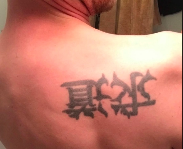 Brush stroke Kanji tattoo on the side of the body.